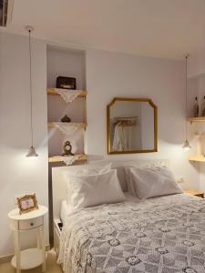 une chambre avec un lit blanc et un miroir dans l'établissement Álas Holiday Home, à Archangelos 27 autres photos