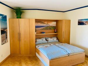 Un dormitorio con una cama y un armario de madera. en 109 im Lord Nelson, en Cuxhaven 16 fotos más