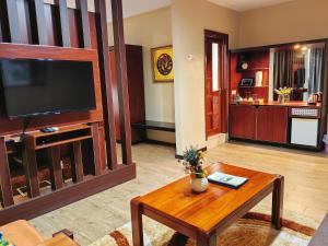 a living room with a television and a coffee table at Great Wall Hotel in Dar es Salaam