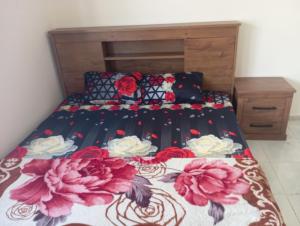 un letto con copriletto e fiori sopra di Full apartment all is yours a Sharjah