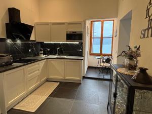 a kitchen with white cabinets and a table and a window at La Randa apartment in Vernazza