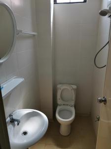 a small bathroom with a toilet and a sink at Sunny Point Hostel in Gelugor