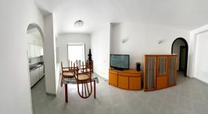 a living room with a television and a table and chair at Timiama Hotel & Apartments in Peschici