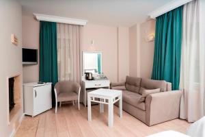 a living room with a couch and a table at Bay Nihat Otel Lale in Ayvalık