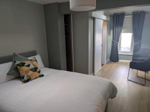 una camera da letto con un letto e una sedia di Eyre Square View a Galway