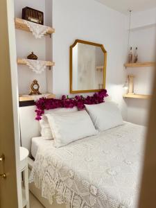 - une chambre avec un lit blanc orné de fleurs violettes dans l'établissement Álas Holiday Home, à Archangelos