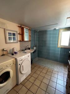 ein Badezimmer mit Waschmaschine und Waschbecken in der Unterkunft Villa Pomme de Pin in Quend-Plage