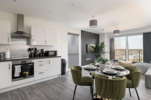 a kitchen and living room with a table and chairs at Lovely Home Near Canal, Park, & Central MK in Milton Keynes