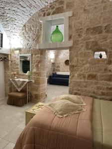 a room with a bed and a stone wall at Suite & Spa La Petra in Ceglie Messapica