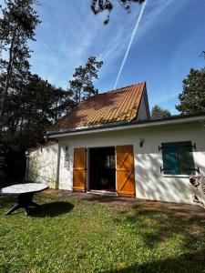 a small white house with a bench in the yard at Villa Pomme de Pin in Quend-Plage