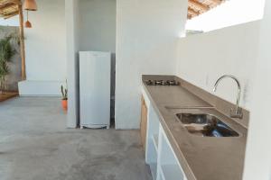 Kuchyň nebo kuchyňský kout v ubytování Apart Charme e Conforto 360m da Praia do Mutá