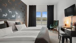 比斯平根Alpine Hotel的一间卧室，里面有一张床、一张桌子和一台电视。