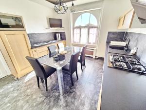 una cucina con tavolo, sedie e fornelli di 731-Maison Bretonne a proximte des plages et des s a Plouhinec