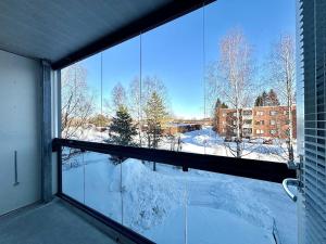 una finestra con vista su un cortile coperto da neve di Cozy apartment in Kuusamo a Kuusamo