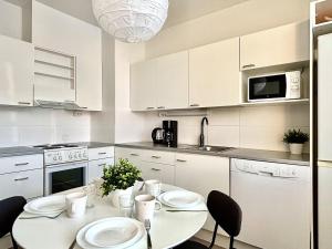 una cucina bianca con tavolo e sedie bianchi di Cozy apartment in Kuusamo a Kuusamo