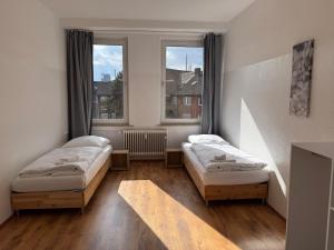 デュースブルクにあるUNGLAUBLICHES ANGEBOT-Duisburg 4 Zimmer Apartmentの窓が2つある部屋にベッドが2つある