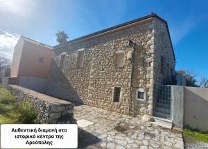 a large stone building with a fence around it at Flame Yard in Areopoli