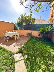 a patio with a table and chairs in a yard at MarePorto House in Fiumicino +17 photos