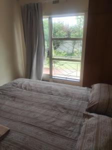 a bedroom with a large bed and a window at Tumelos Place in Bloemfontein