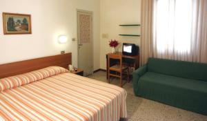 a hotel room with a bed and a green couch at Hotel Garni Picnic in Riccione