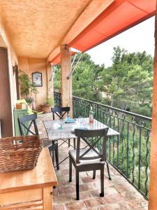 Un patio con una mesa y sillas en un balcón. en T2 55 m2 avec terrasse 25 m2, en La Ciotat