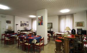 a restaurant with tables and chairs in a room at Hotel Garni Picnic in Riccione