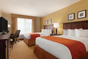 a hotel room with two beds and a flat screen tv at Country Inn & Suites by Radisson, Columbia at Harbison, SC in Columbia