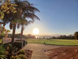 Una vista del atardecer desde un parque con palmeras. en The 10th Hole - Golf Estate, en Villiersdorp 10 fotos más
