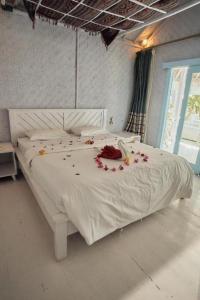 uma cama branca com flores num quarto em Dream CoWork Hotel em Kuta Lombok