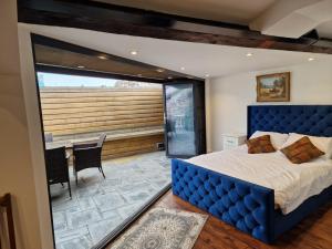 a bedroom with a large blue bed and a table at Luxury Barbican Apartment in Plymouth +87 photos