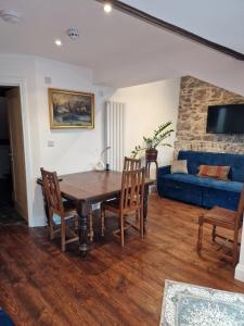 a living room with a wooden table and a blue couch at Luxury Barbican Apartment in Plymouth