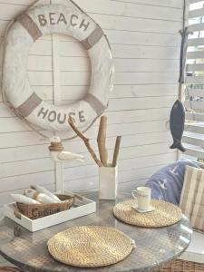 a glass table with a beach house sign and a mirror at Beach House in Międzyzdroje