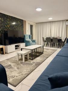 a living room with a tv and a couch and a table at Sky2030Group in Dammam