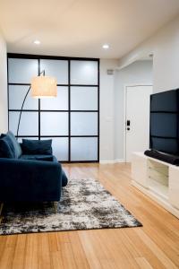 a living room with a blue couch and a television at Cozy Home with Backyard & Fire Pit in West New York