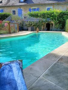a person swimming in a swimming pool at Chambre d'hôtes de la dame blanche in Borrèze