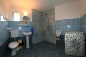 a bathroom with a sink and a toilet and a urinal at Casa Nelu Pescaru in Mahmudia +50 photos
