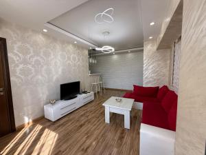 a living room with a red couch and a tv at Apartment in Tumanyan street in Yerevan