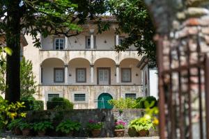 an old building with a green door in a garden at Case Bernardini - Historic Tuscan Estate in Coreglia Antelminelli +44 photos