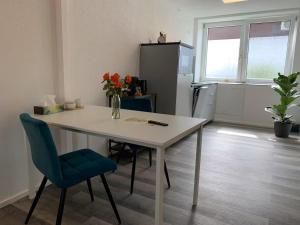 a kitchen with a table and a vase with flowers on it at Luxus Appartement Motel Ambiente 2 in Bad Säckingen +1 photo