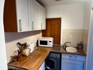 a small kitchen with a sink and a microwave at Self-contained Guest Suite, Michelmersh, Romsey in Michelmersh