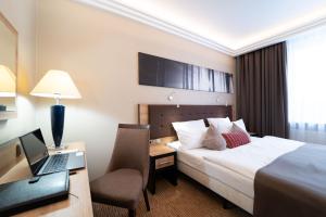 ein Hotelzimmer mit Bett und Schreibtisch mit Laptop in der Unterkunft Hotel Festival in Oppeln + 49 Fotos