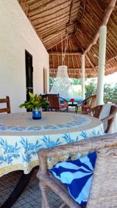 a patio with a table and chairs in a pavilion at Les Datchi Cottages in Diani Beach