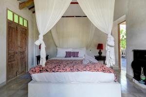 una camera da letto con un grande letto a baldacchino di Beautiful Rustic 3bd Villa in Bingin a Uluwatu