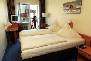 a hotel room with a bed with pillows on it at Hotel Boulevard - Superior in Cologne