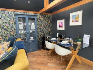 a living room with a yellow couch and a table at Little Monks Suite in Offenham
