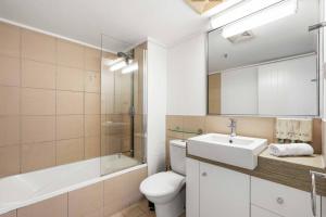 a bathroom with a sink and a toilet and a mirror at Inner City Gem - Stunning Views in Cairns