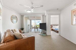 a living room with a couch and a television at Inner City Gem - Stunning Views in Cairns