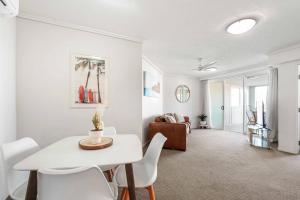 a living room with a white table and chairs at Inner City Gem - Stunning Views in Cairns +14 photos