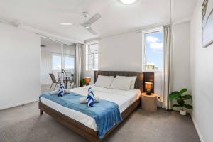 a bedroom with a large bed with a blue blanket at Inner City Gem - Stunning Views in Cairns