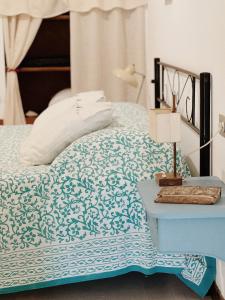 - un lit avec une couverture bleue et blanche et une table dans l'établissement Casa nel borgo, à Domaso